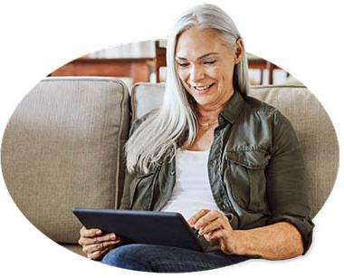 Woman sitting on couch reading her iPad.